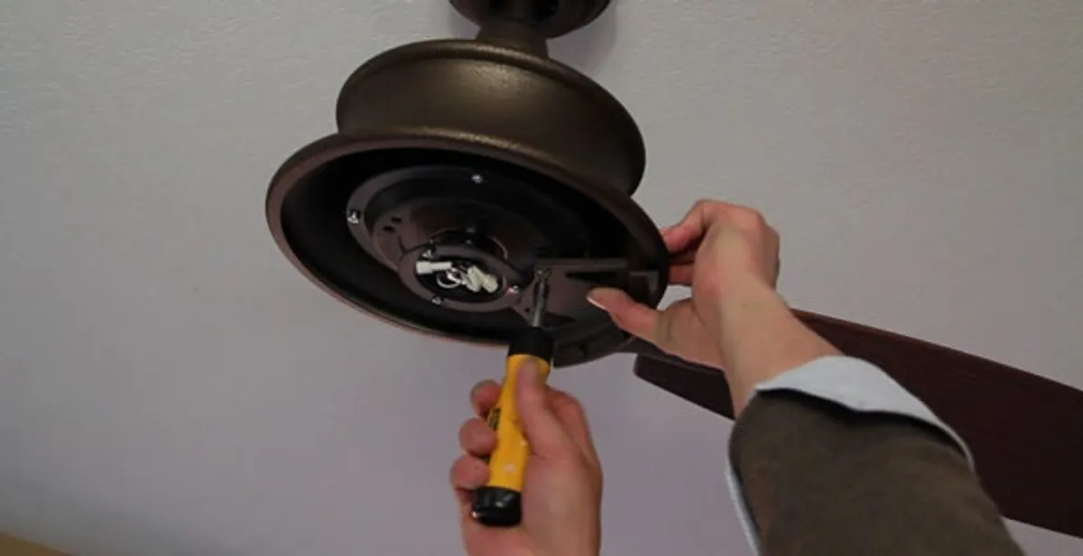 Electrician installing ceiling fan mounting bracket and fixture in Mesa, AZ