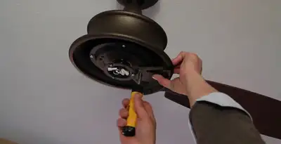 Electrician installing ceiling fan mounting bracket and fixture in Mesa, AZ