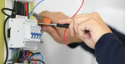 Electrician installing and adjusting circuit breakers in an electrical panel in Mesa, AZ