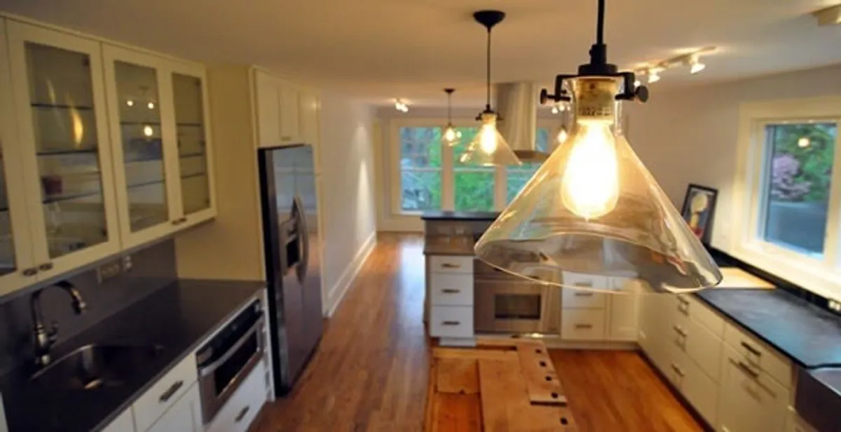Residential electrician installing modern indoor light fixture in a home in Mesa, AZ