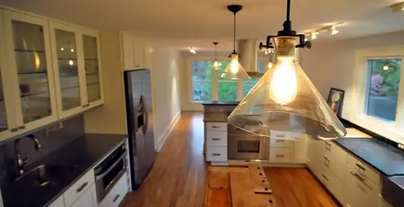 Residential electrician installing modern indoor light fixture in a home in Mesa, AZ